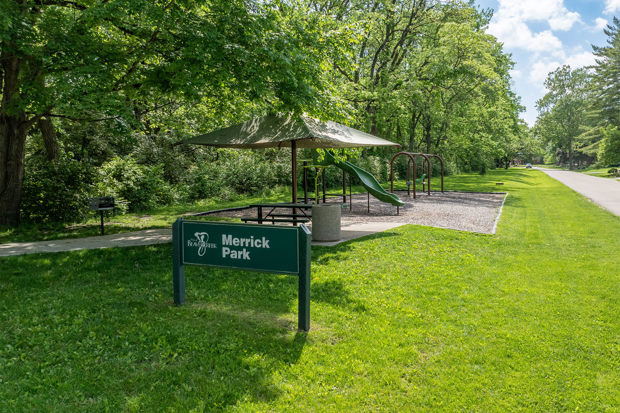 Merrick Park sign in front of covered picnic table and playground