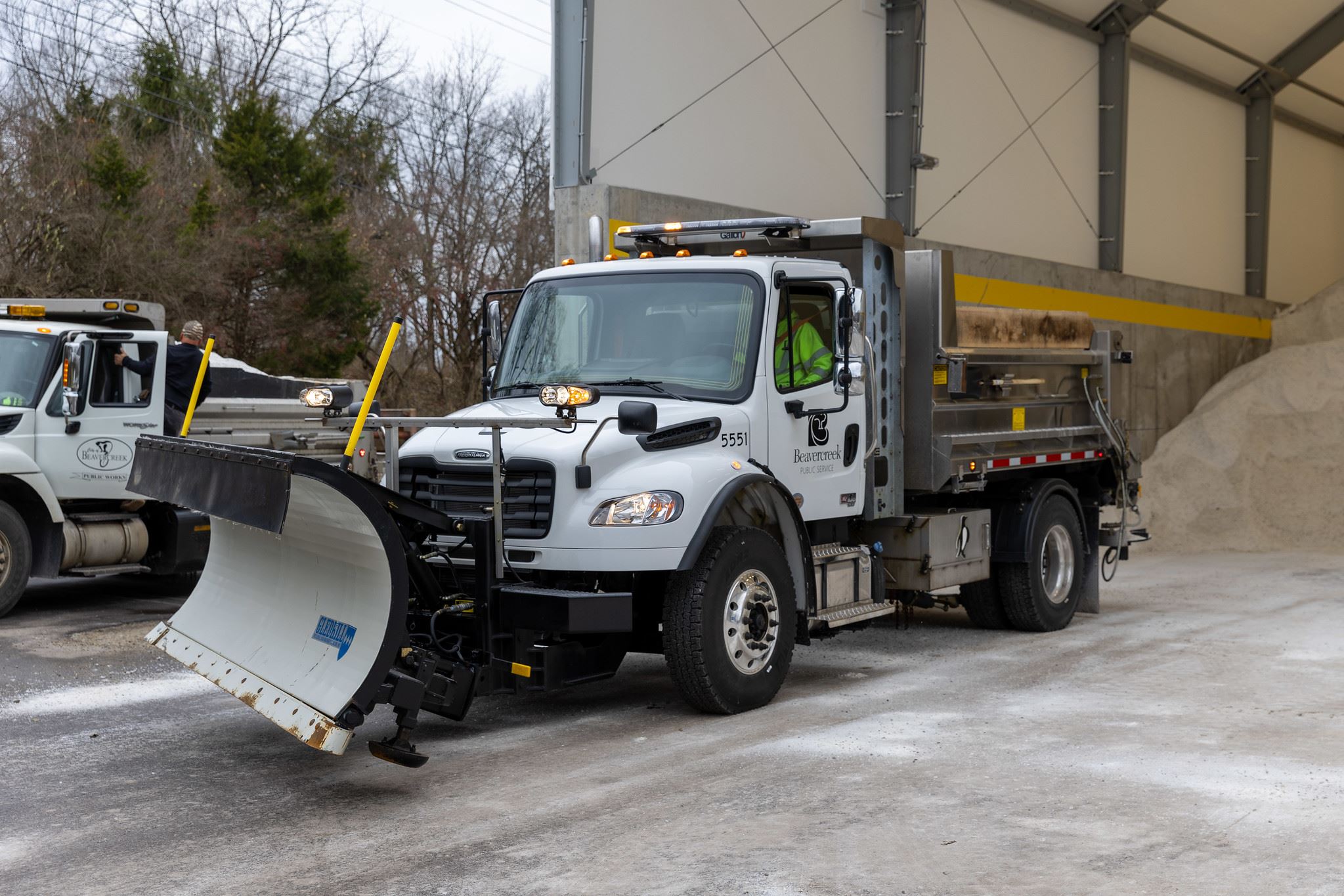 A Beavercreek Public Service snowplow truck is parked inside a salt storage facility